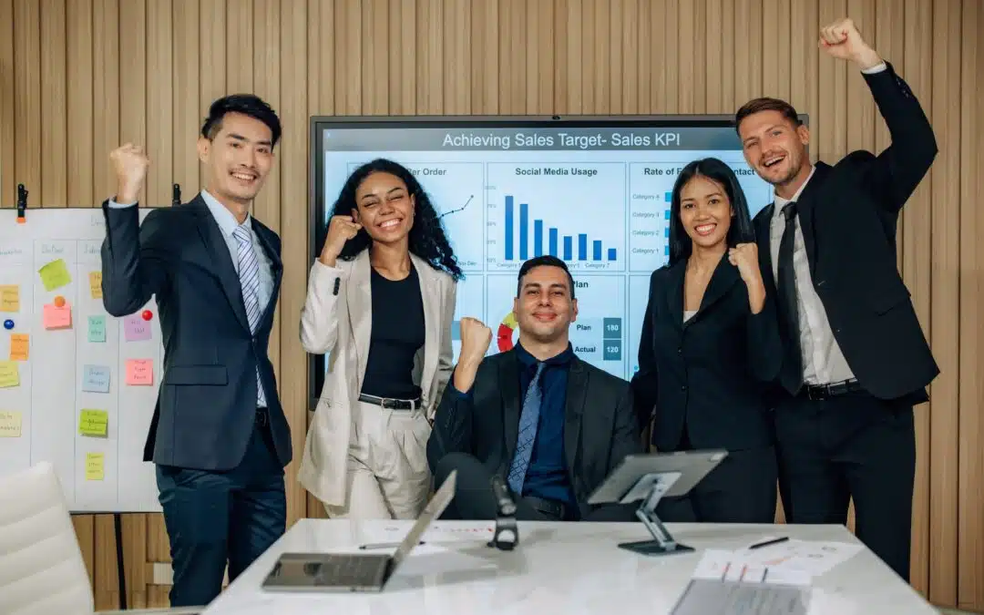 A group of business people posing in front of a screen.