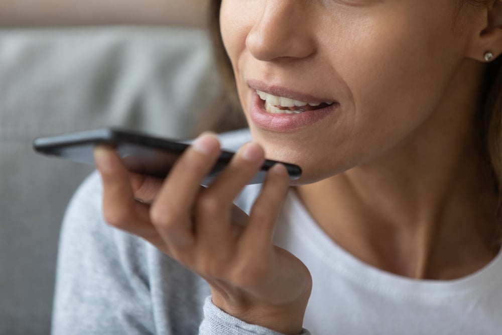 Close-up of a woman holding a smartphone Voice Search optimization sarasota county